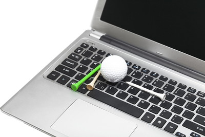 Golf Ball and Tees on Laptop